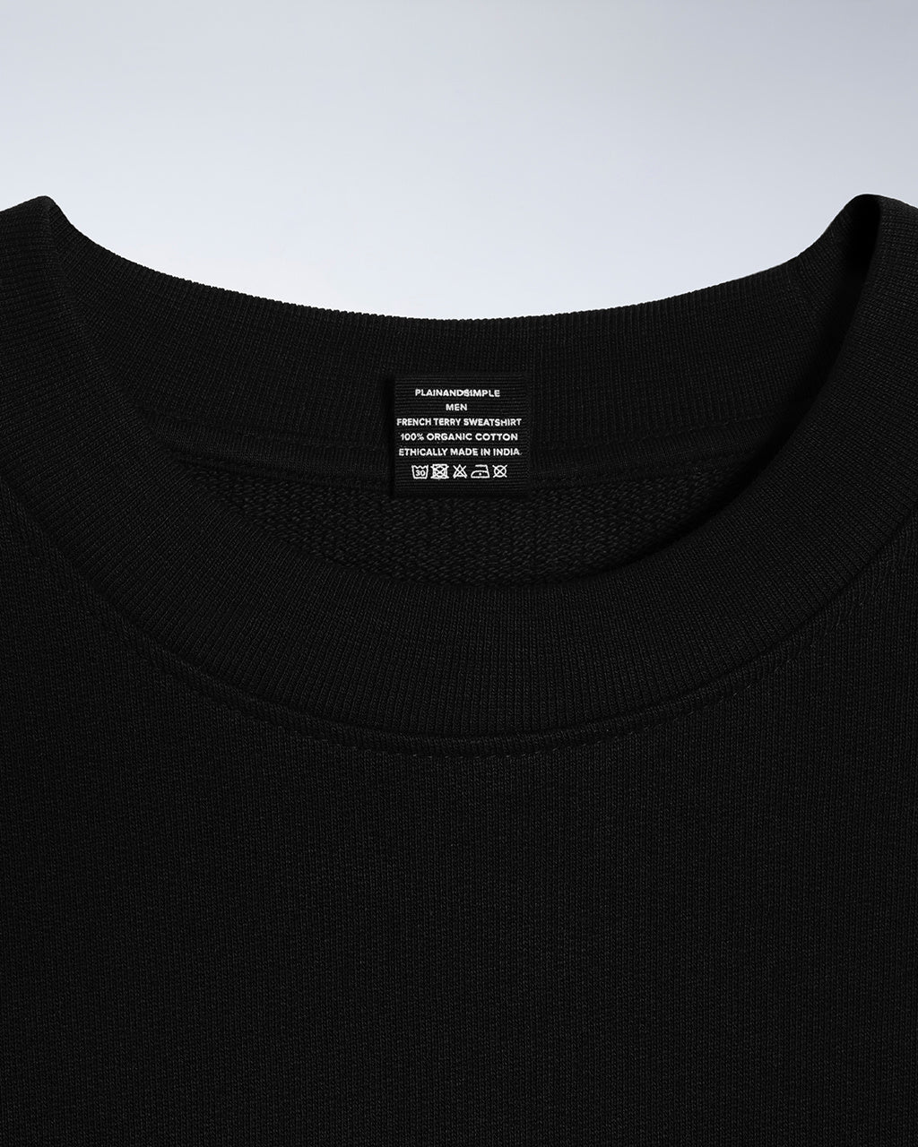 A close up of an neck label in a men's black organic cotton sweatshirt.