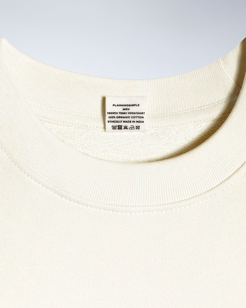 A close up of an neck label in a men's ecru organic cotton sweatshirt.