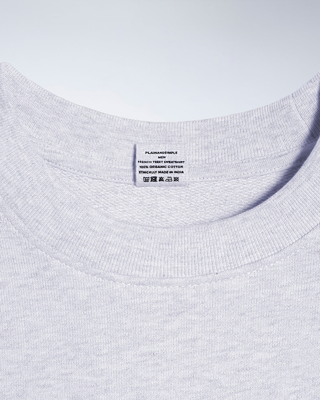 A close up of an neck label in a men's grey organic cotton sweatshirt.