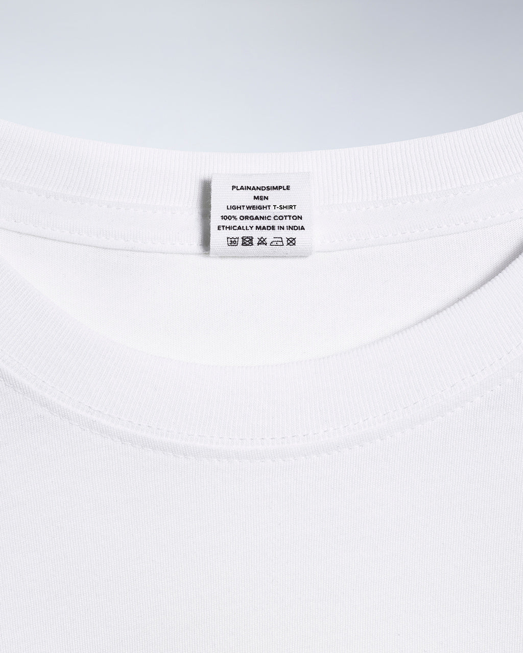 A close up of an neck label in a men's white short sleeve lightweight organic cotton t shirt.