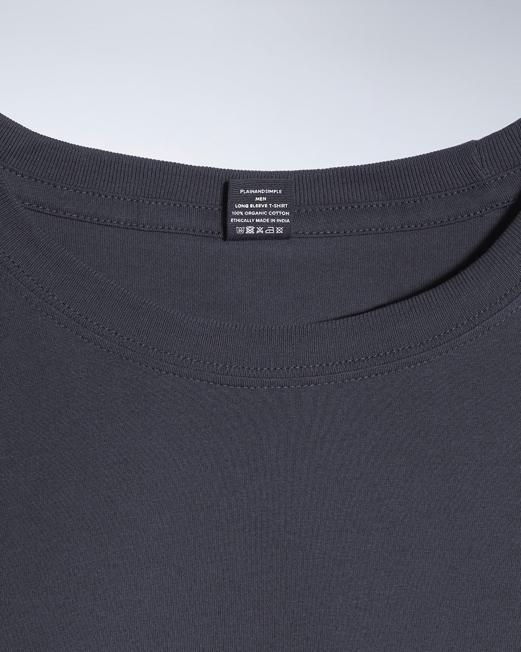 A close up of a neck label in a men's dark grey long sleeve crew neck organic cotton t shirt.