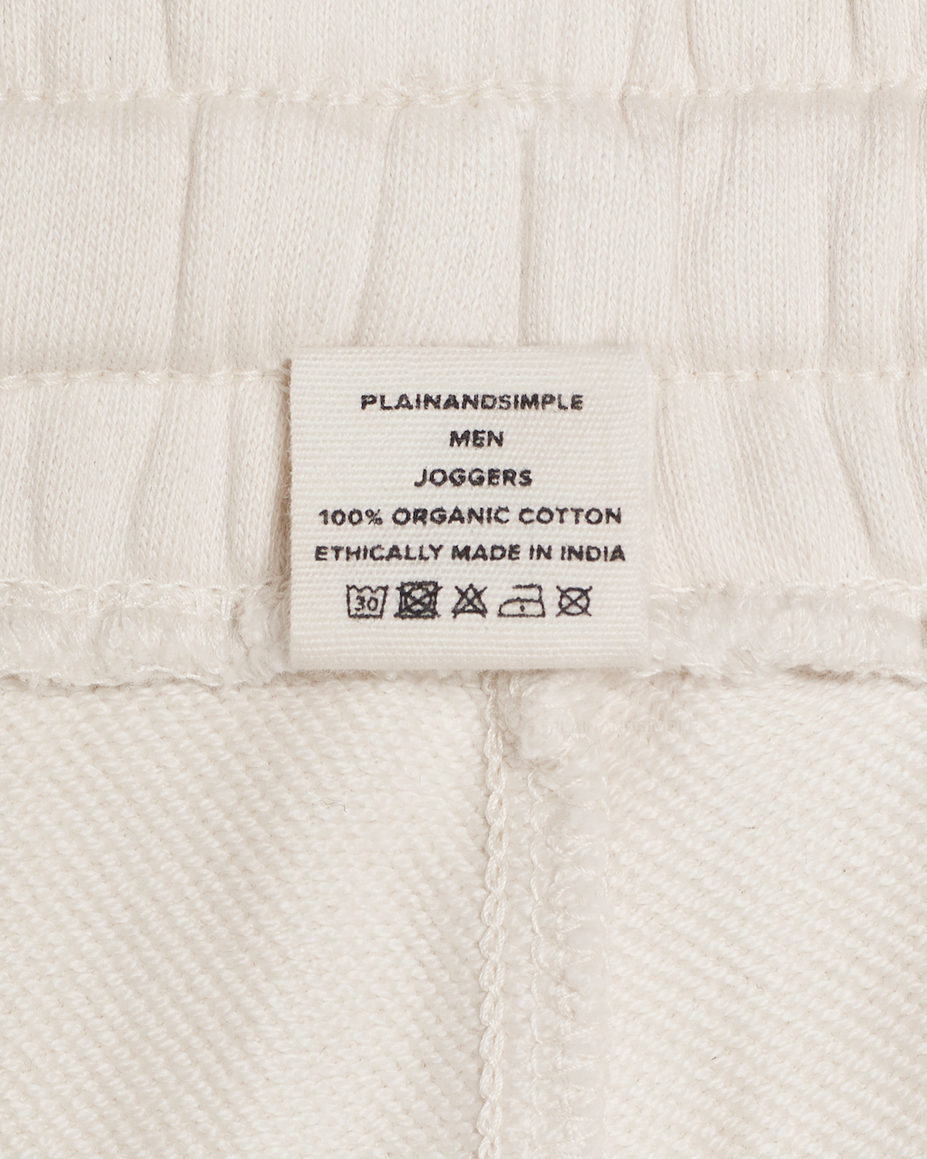 A close up of the label in a pair of natural coloured, organic cotton joggers.