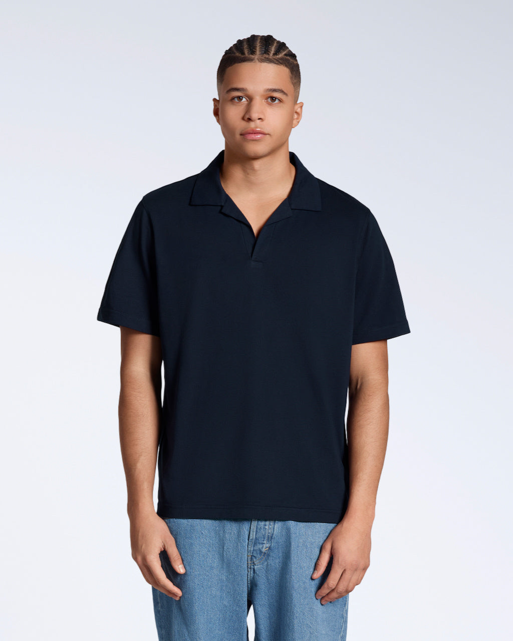 A man facing front on, modelling a plain navy, short sleeve organic cotton polo shirt.