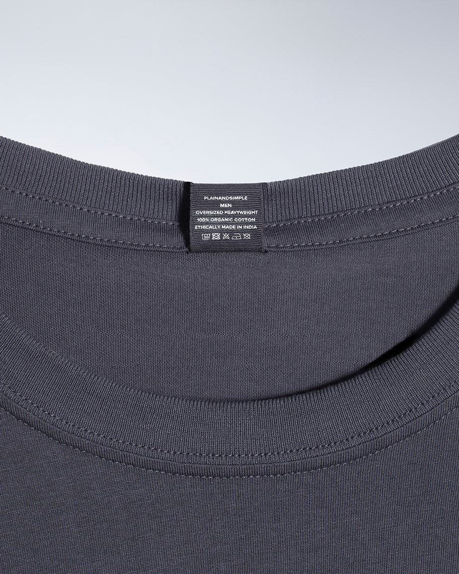 A close up of a neck label in a men's dark grey, oversized heavyweight, organic cotton t shirt.