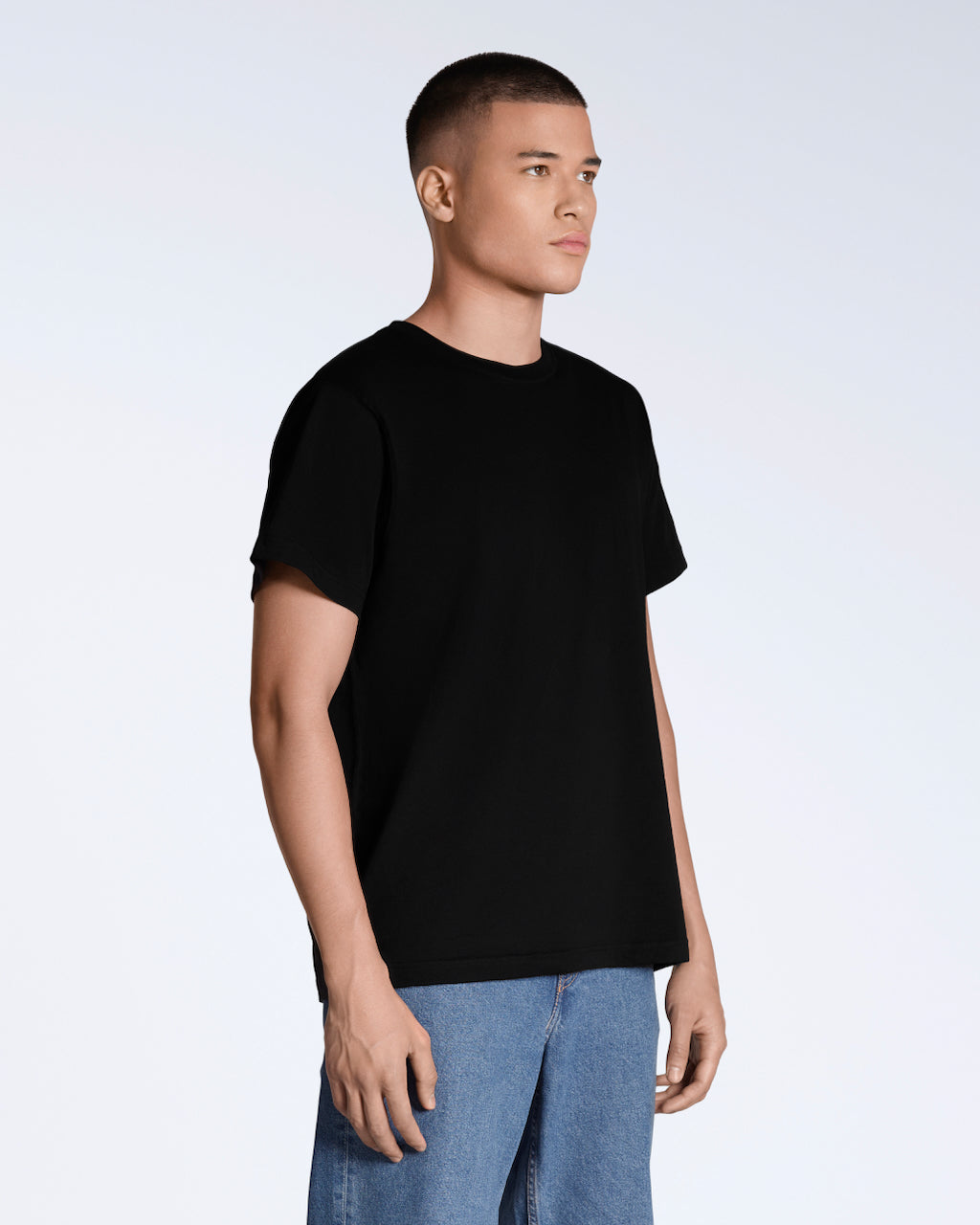 A man at an angle with his arms by his sides, modelling a plain black short sleeve organic cotton t shirt.