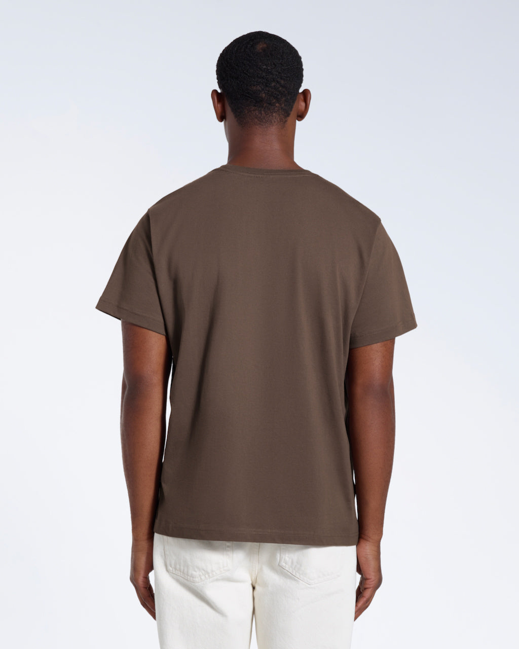 A man facing away from the camera, modelling a plain dark khaki short sleeve organic cotton t shirt.