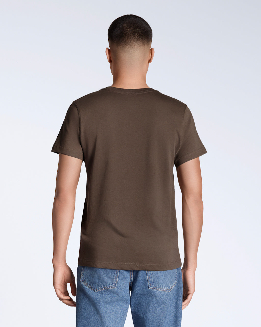 A man facing away from the camera, modelling a plain brown short sleeve organic cotton t shirt.