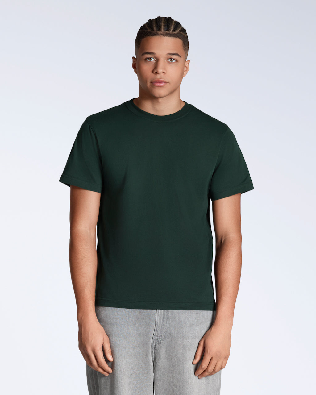A man facing front on looking into the camera, modelling a plain green, organic cotton t shirt.
