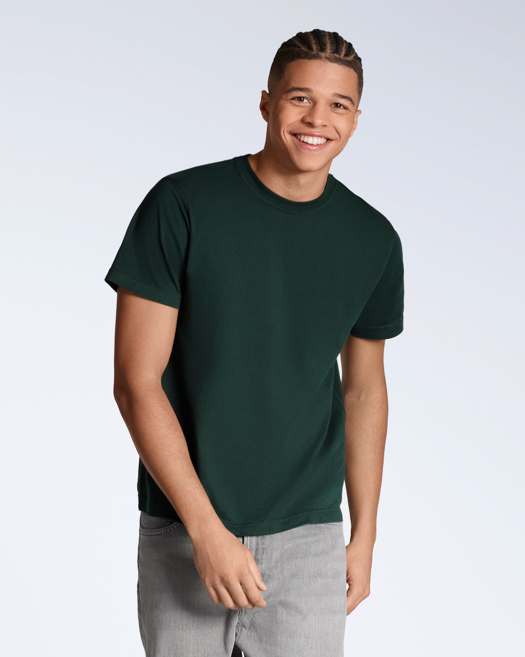 A man smiling into the camera, modelling a plain green, organic cotton t shirt.