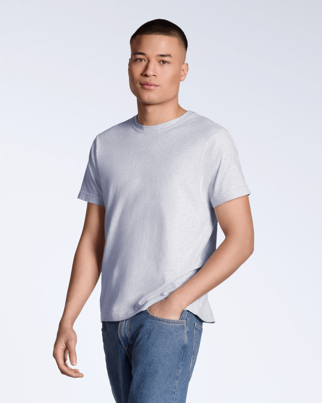 A man looking into the camera with his hand in his pocket, modelling a plain grey short sleeve organic cotton t shirt.