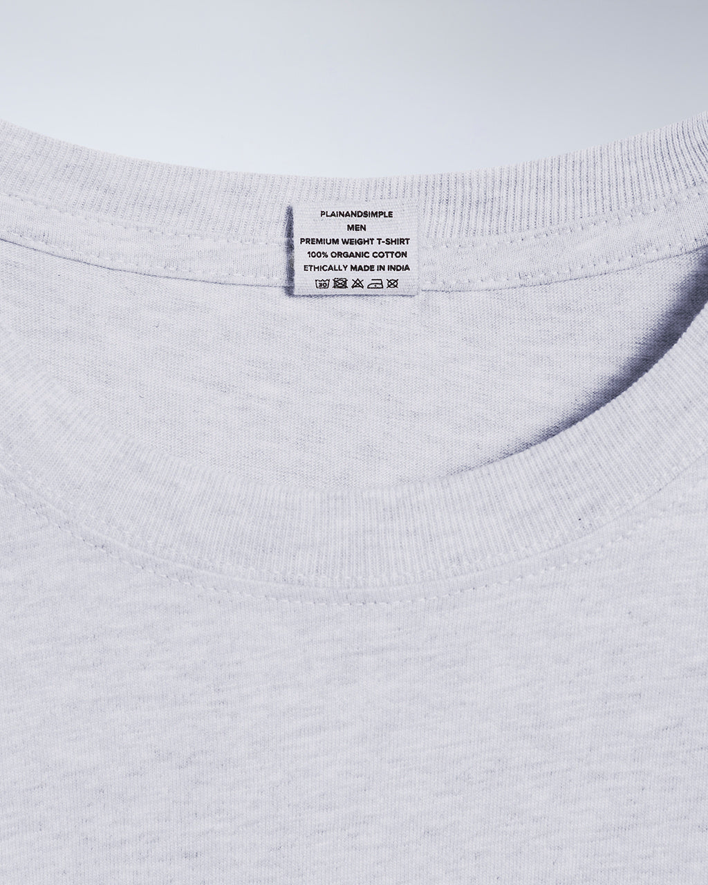 A close up of a neck label in a men's grey short sleeve crew neck organic cotton t shirt.