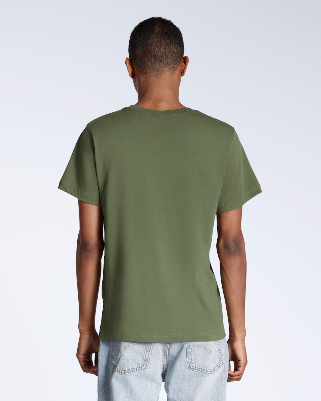 A man facing away from the camera, modelling a plain khaki green short sleeve organic cotton t shirt.