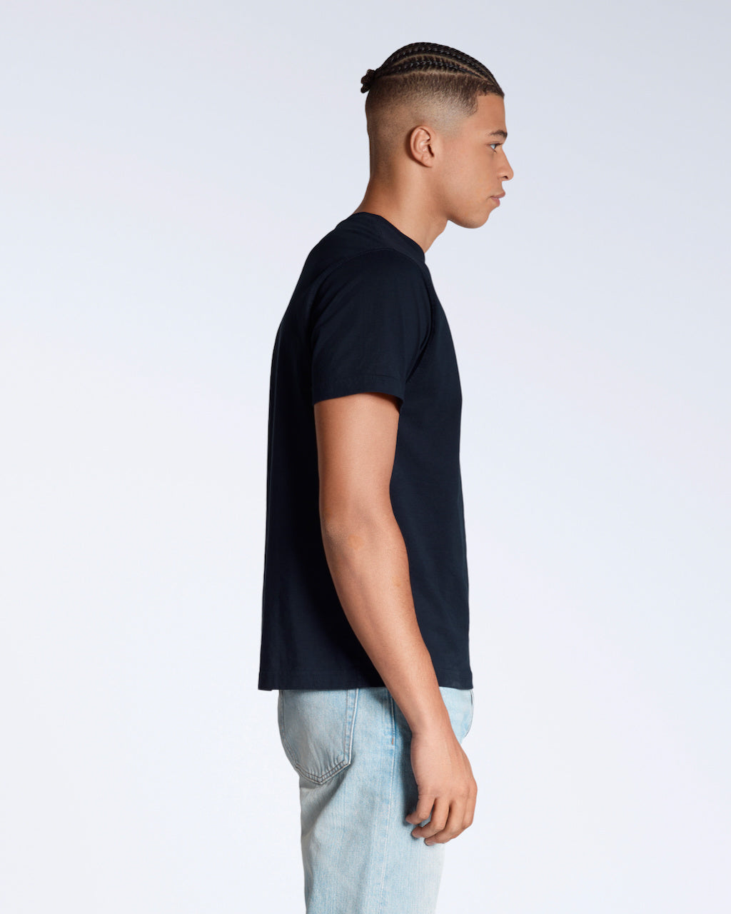 A man facing side on, modelling a plain navy short sleeve organic cotton t shirt.