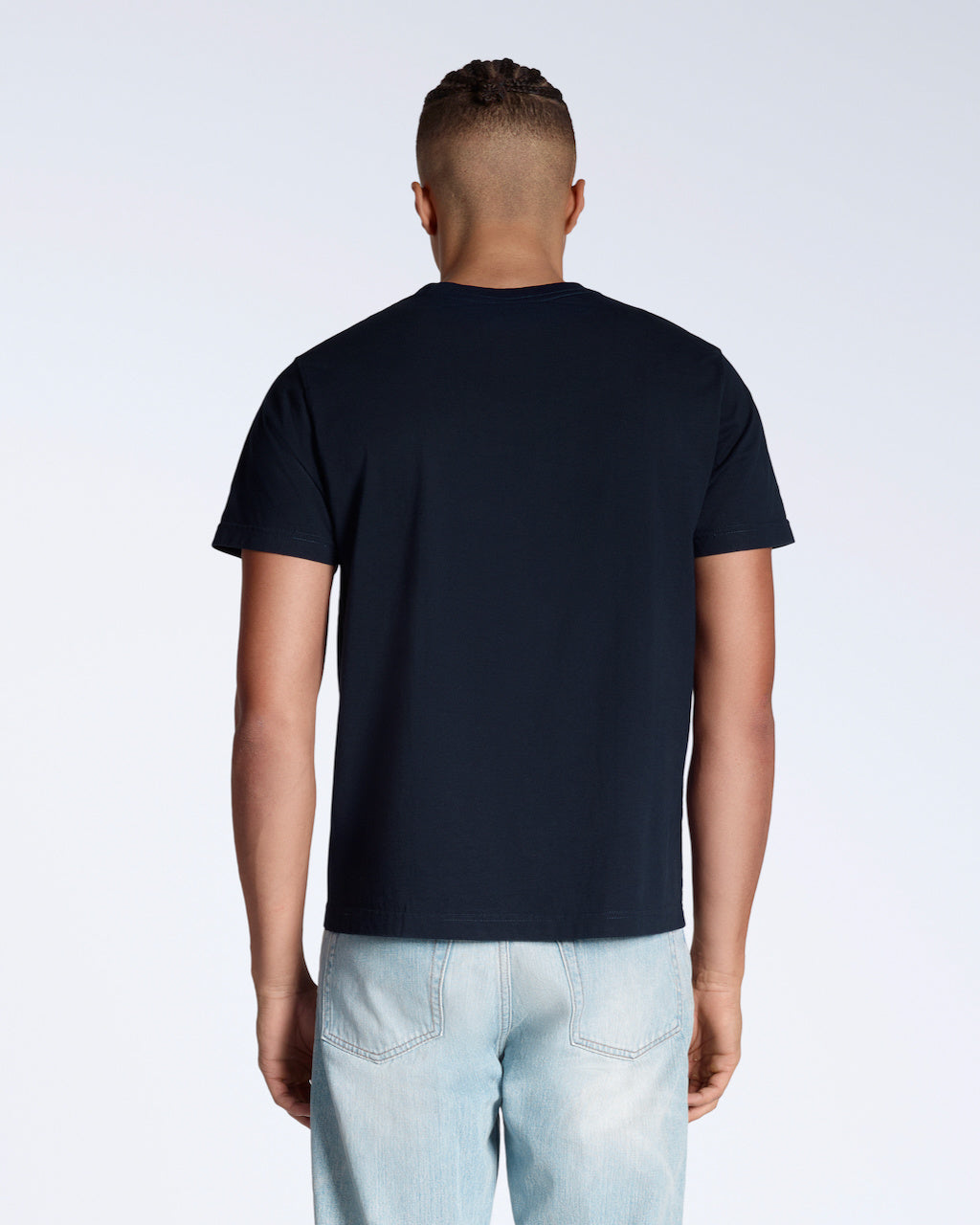 A man facing away from the camera, modelling a plain navy short sleeve organic cotton t shirt.