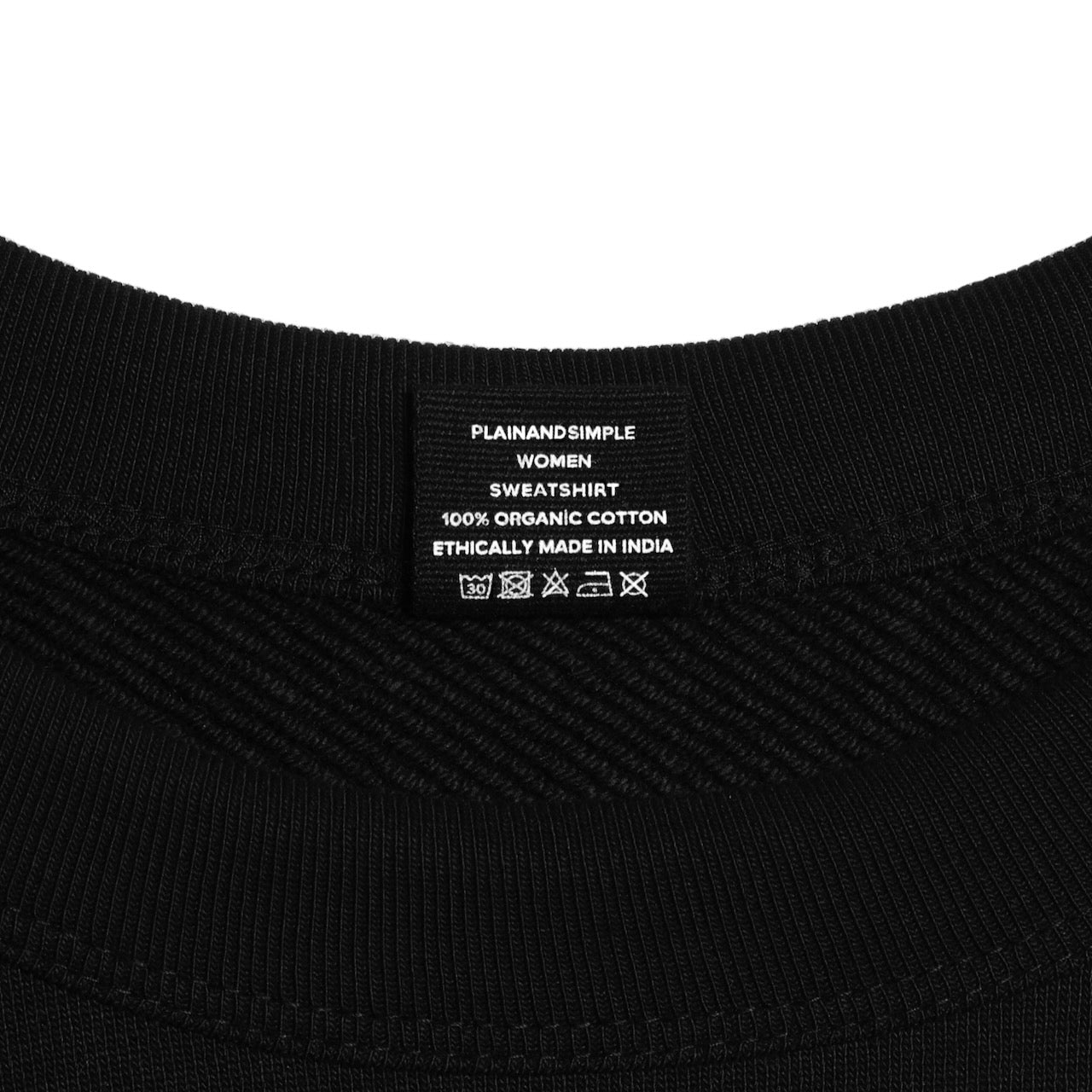 A close up of an neck label in a women's black heavyweight organic cotton sweatshirt.