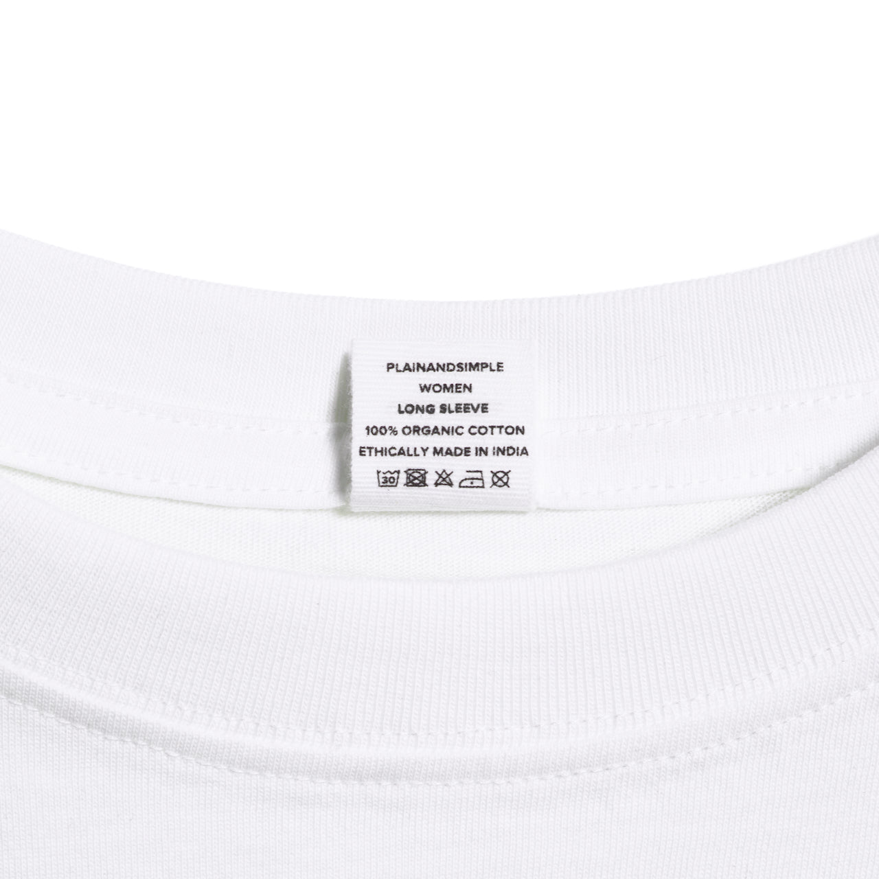 A close up of an neck label in a women's white long sleeve crew neck organic cotton t shirt.