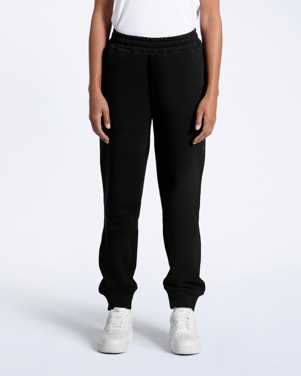 A woman facing front on with her hands by her side, modelling a pair of black organic cotton joggers.