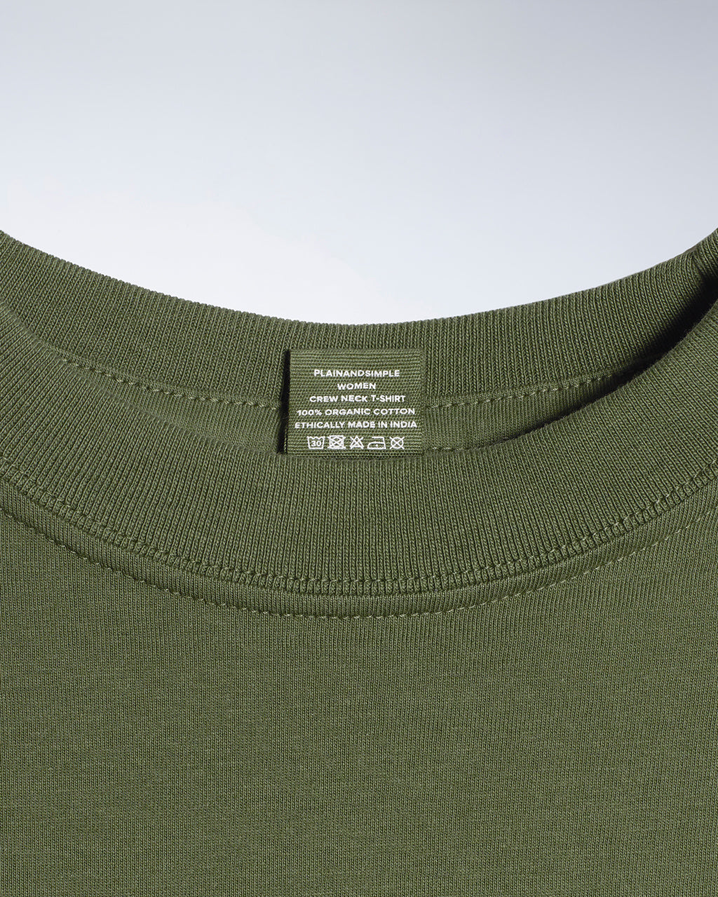 A close up of a neck label in a women's khaki green short sleeve crew neck organic cotton t shirt.