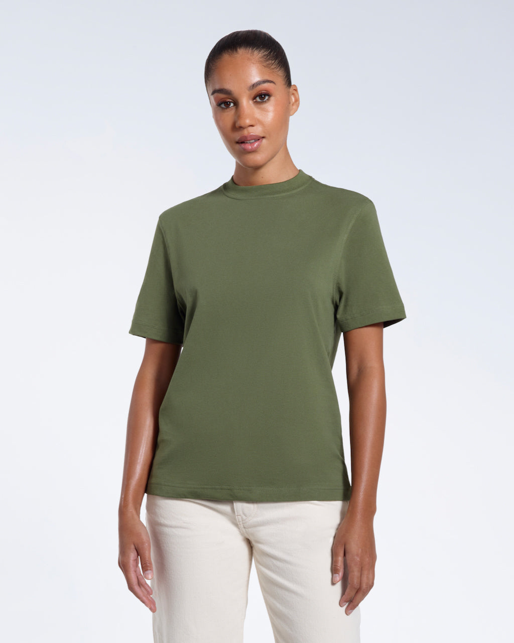 A woman facing front on looking at the camera, modelling a khaki green short sleeve organic cotton t shirt.