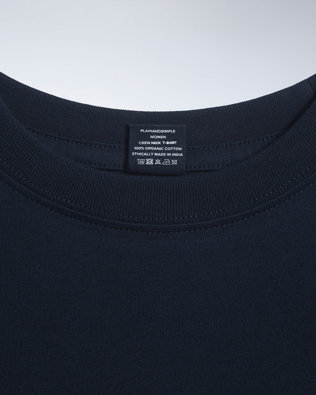 A close up of an neck label in a women's navy short sleeve crew neck organic cotton t shirt.