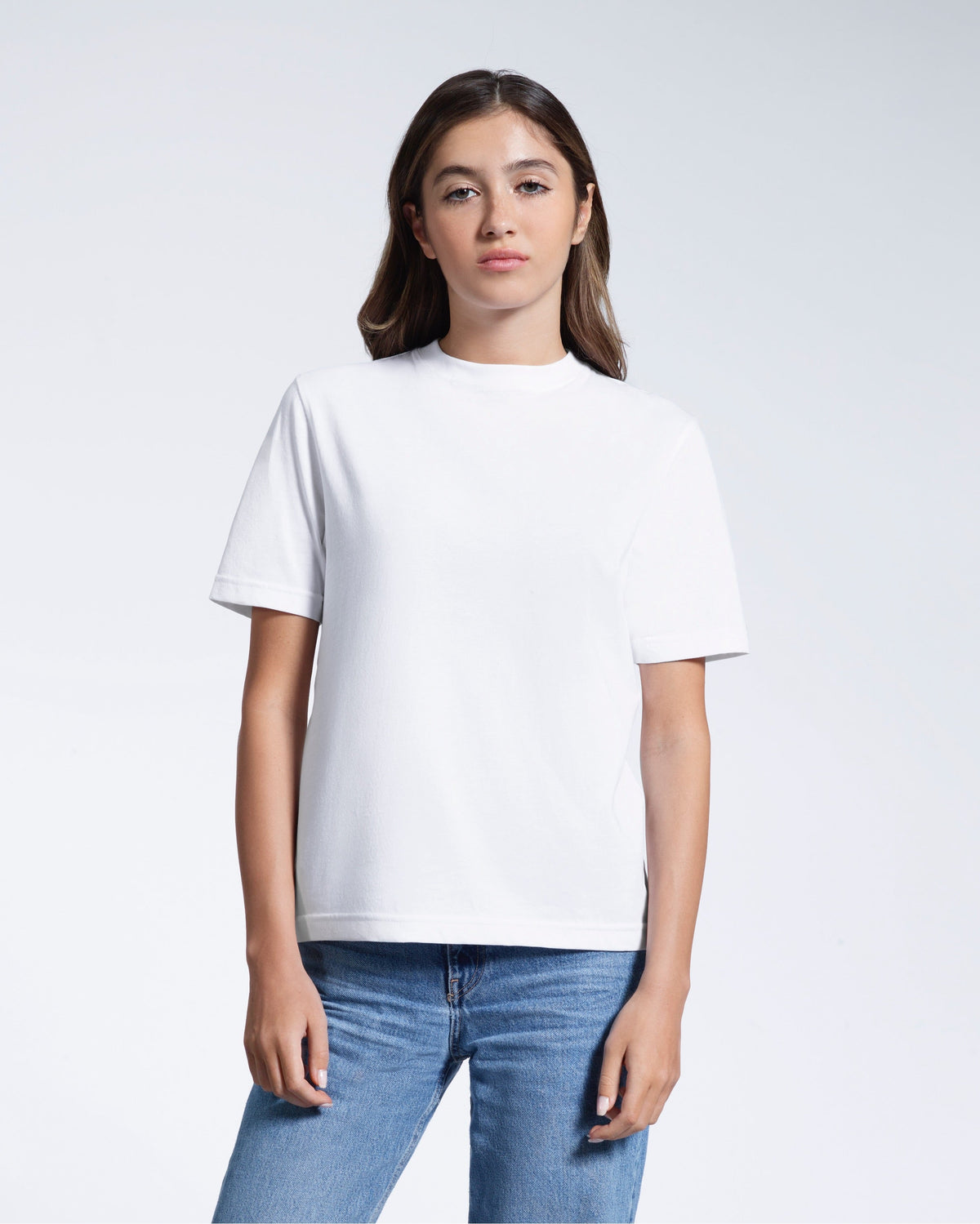 A woman facing front on looking at the camera, modelling a white short sleeve organic cotton t shirt.