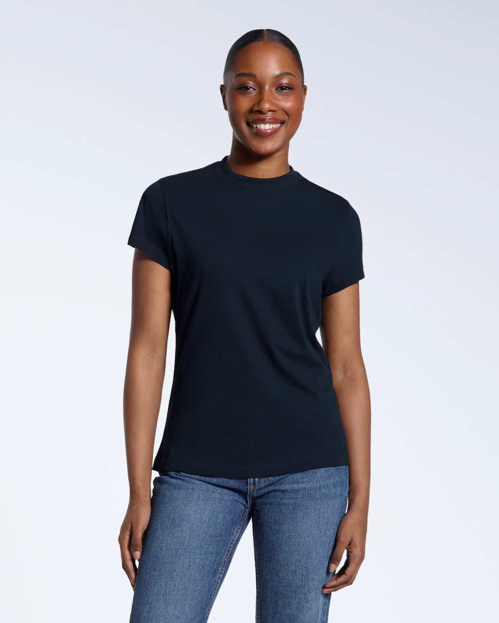 A woman facing front on smiling into the camera, modelling a plain navy short sleeve organic cotton t shirt.