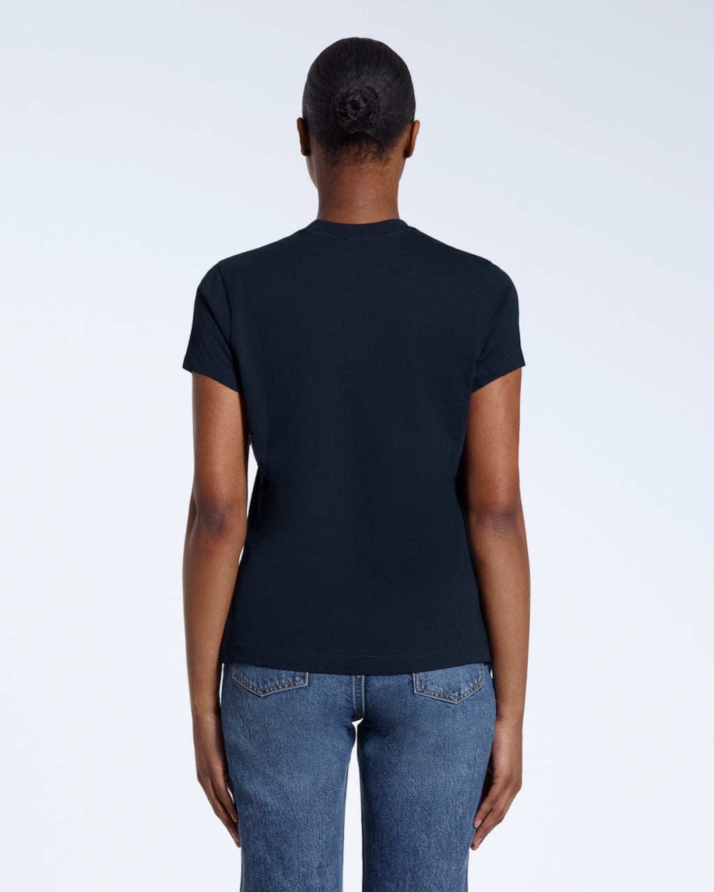 A woman with her back to the camera, modelling a plain navy short sleeve organic cotton t shirt.