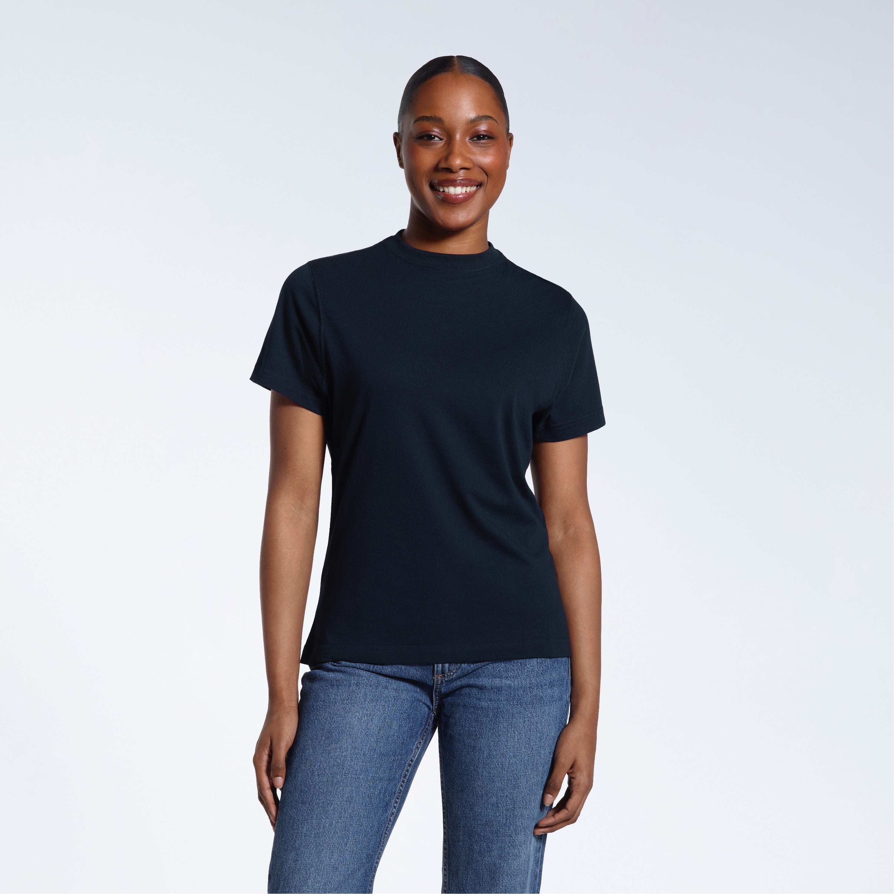 A woman facing front on smiling into the camera, modelling a plain navy short sleeve organic cotton t shirt.
