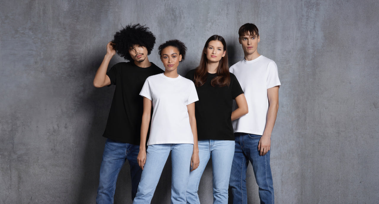 Two women and two men looking into the camera, modelling plain black and white short sleeve organic cotton t shirts.