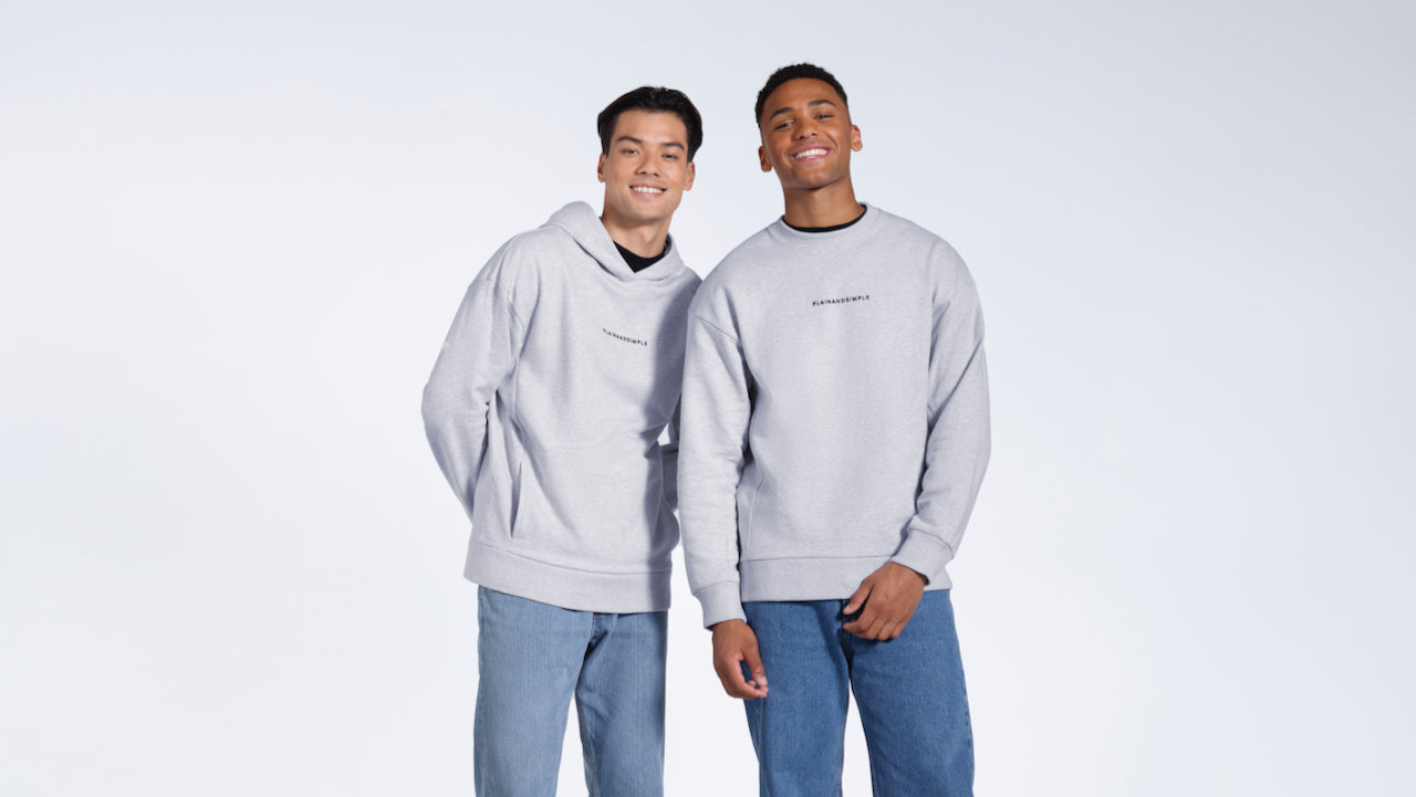 Two men looking into the camera smiling, modelling a grey branded heavyweight organic cotton hoodie and sweatshirt.