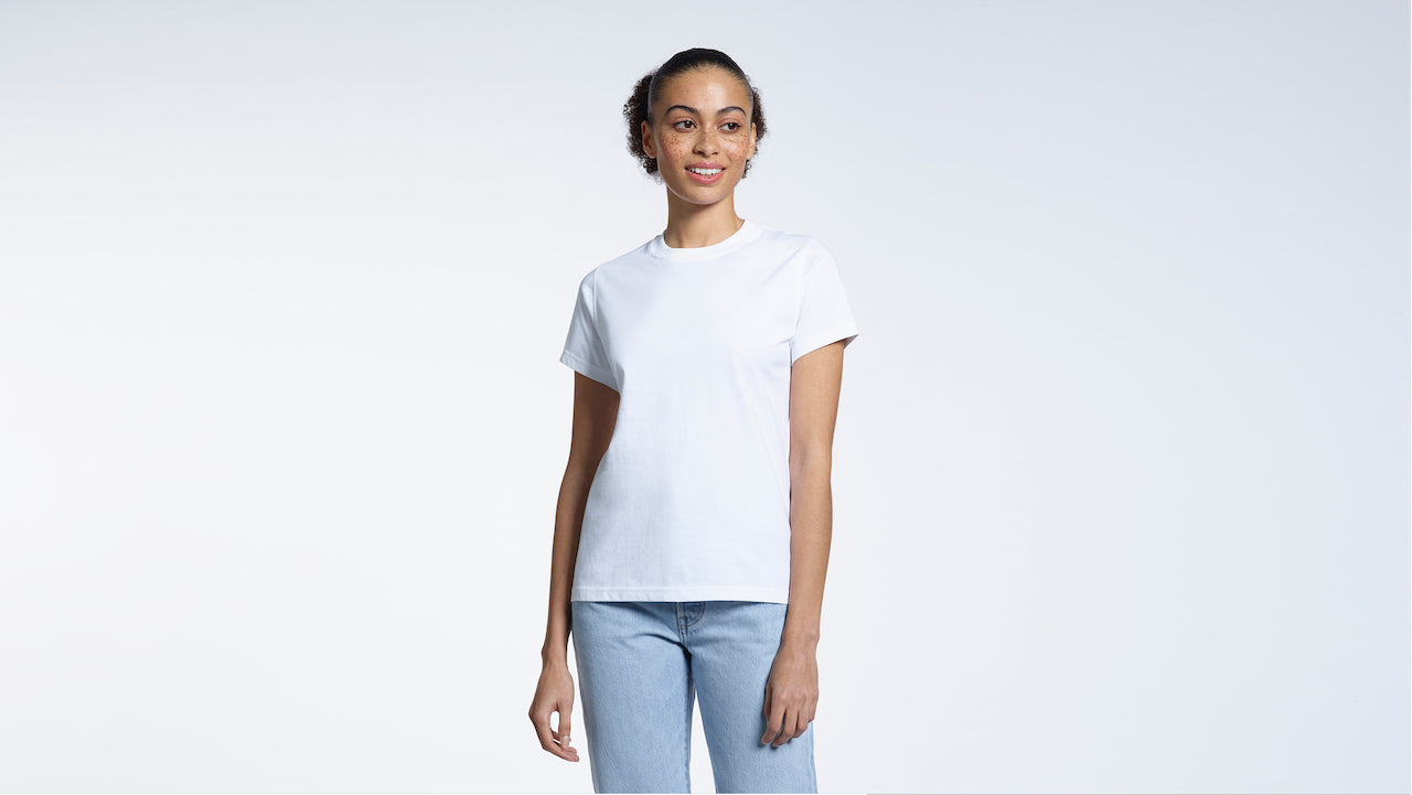 A woman smiling, modelling a plain white organic cotton t shirt.