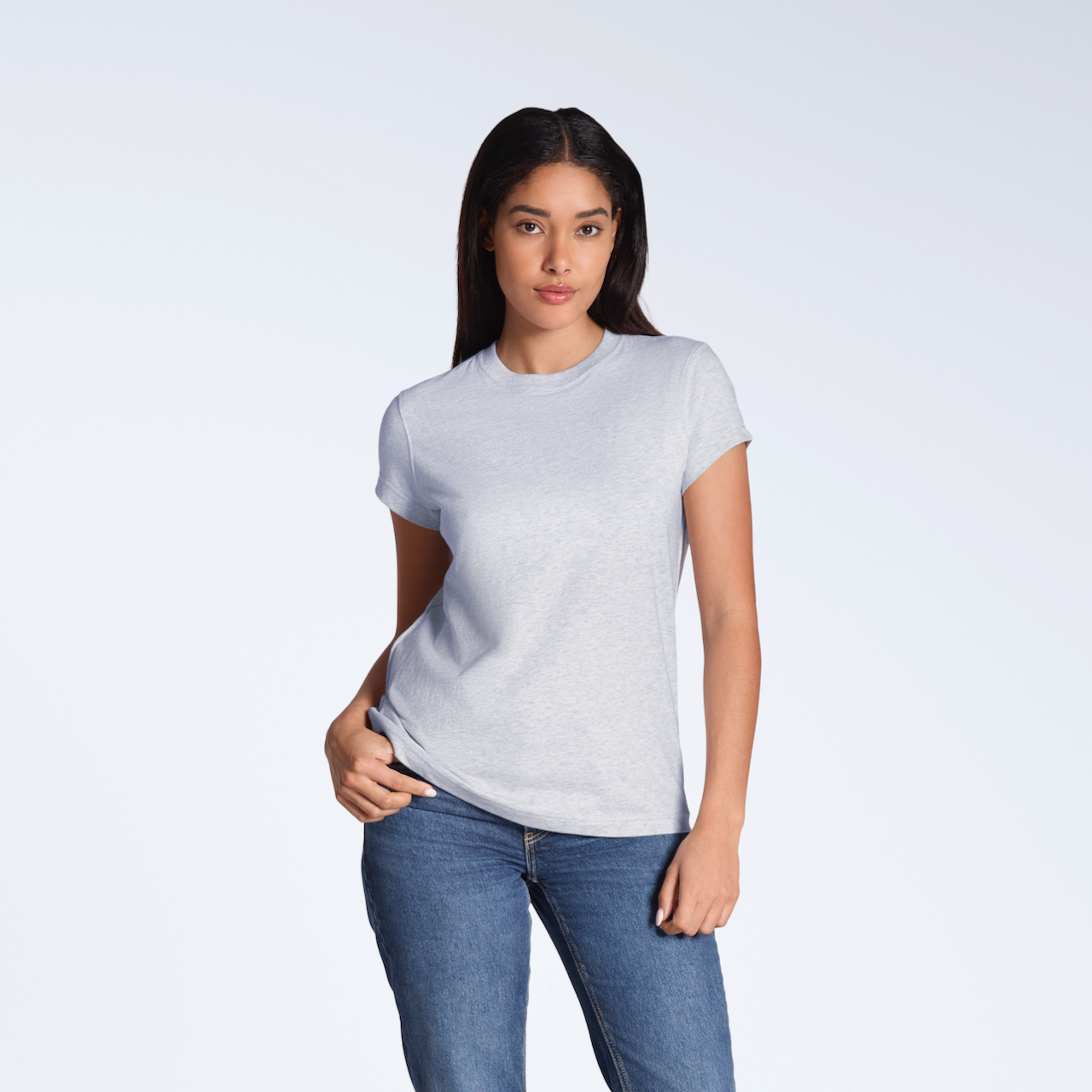 A woman looking into the camera with her hand on her hip, modelling a plain grey, organic cotton t shirt.