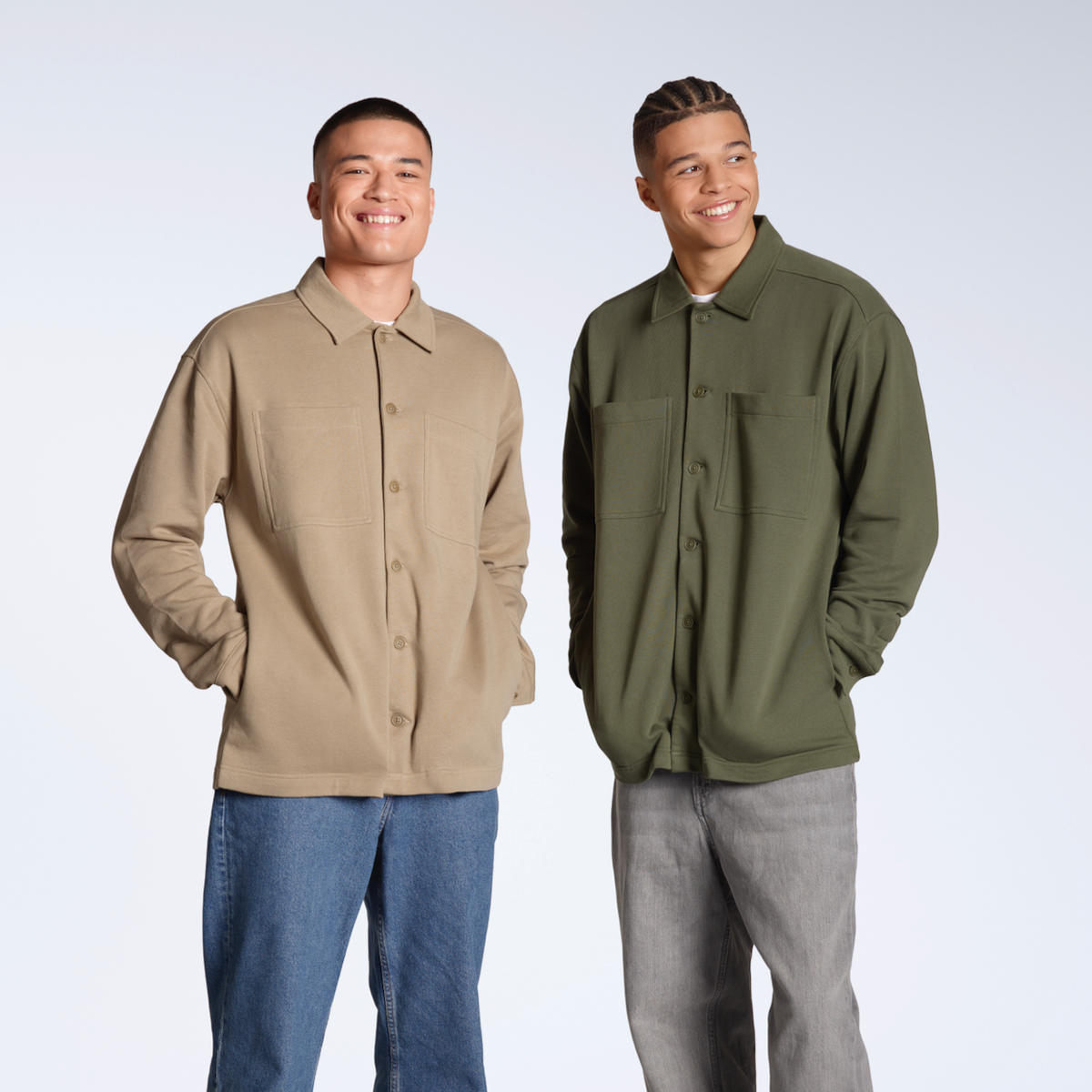 Two men smiling into the camera, modelling plain beige and olive, organic cotton overshirts.