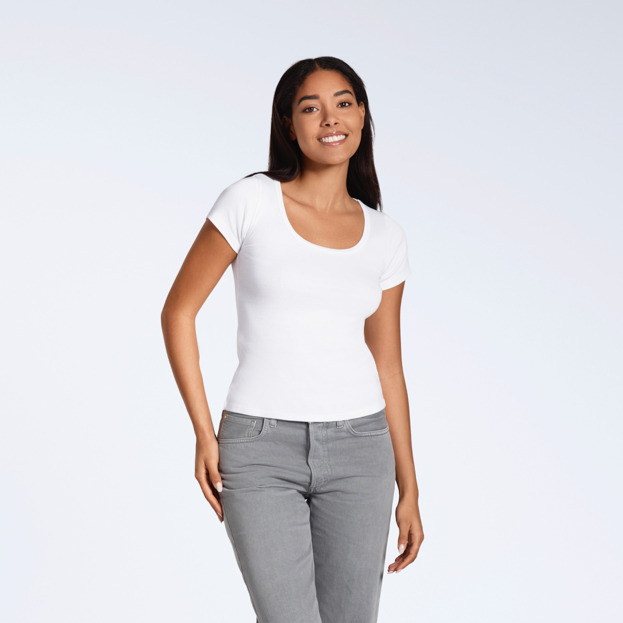A woman smiling into the camera, modelling a plain white, organic cotton scoop neck t shirt.