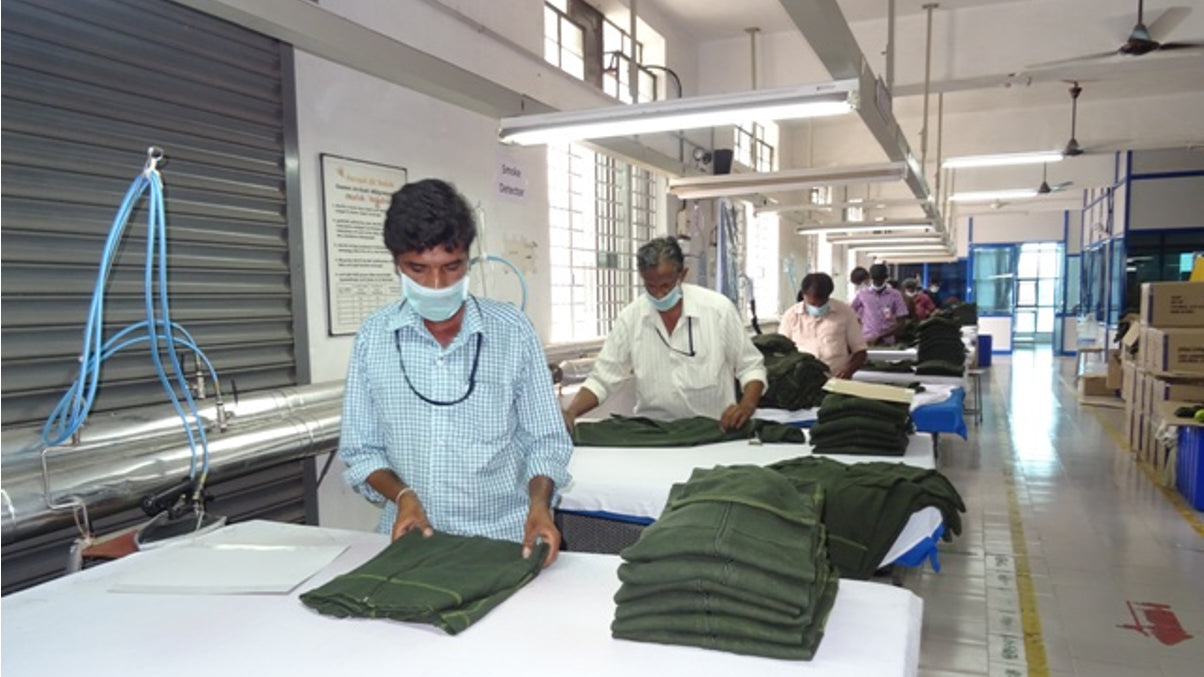 A photo of factory workers ironing clothes at an ethical factory in India.