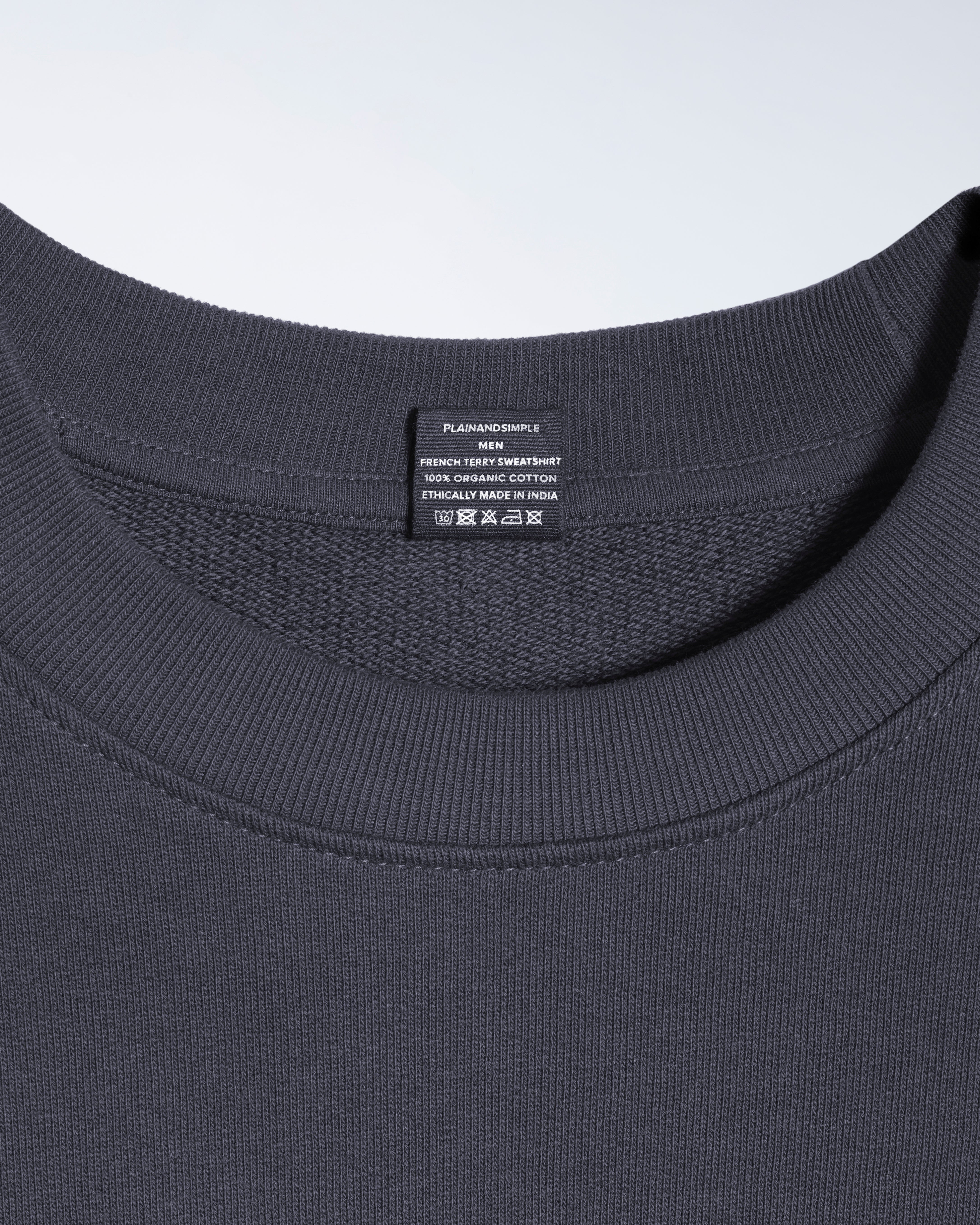 A close up of an neck label in a men's dark grey organic cotton sweatshirt.
