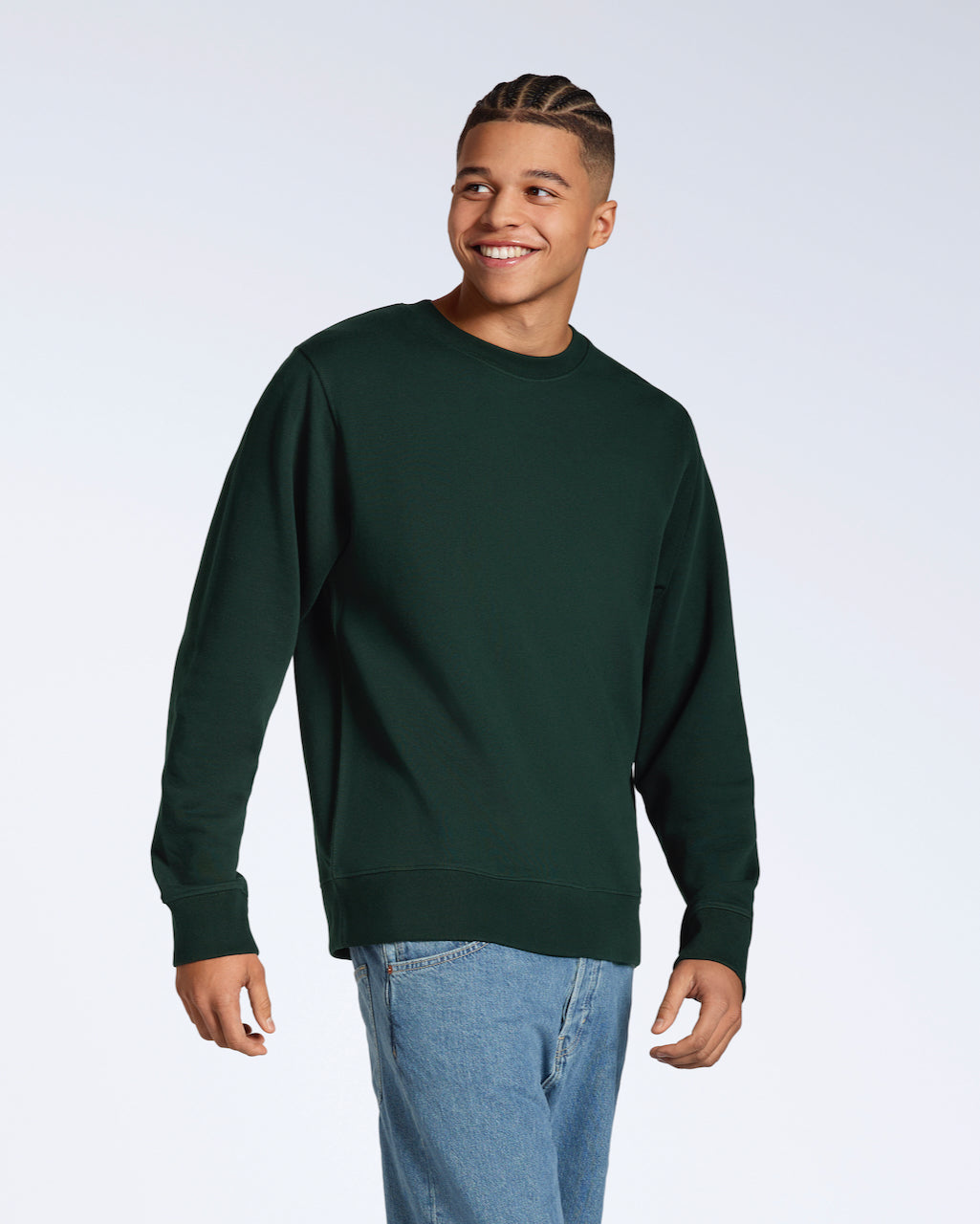 A man smiling, looking away from the camera, modelling a plain dark green french terry organic cotton sweatshirt.