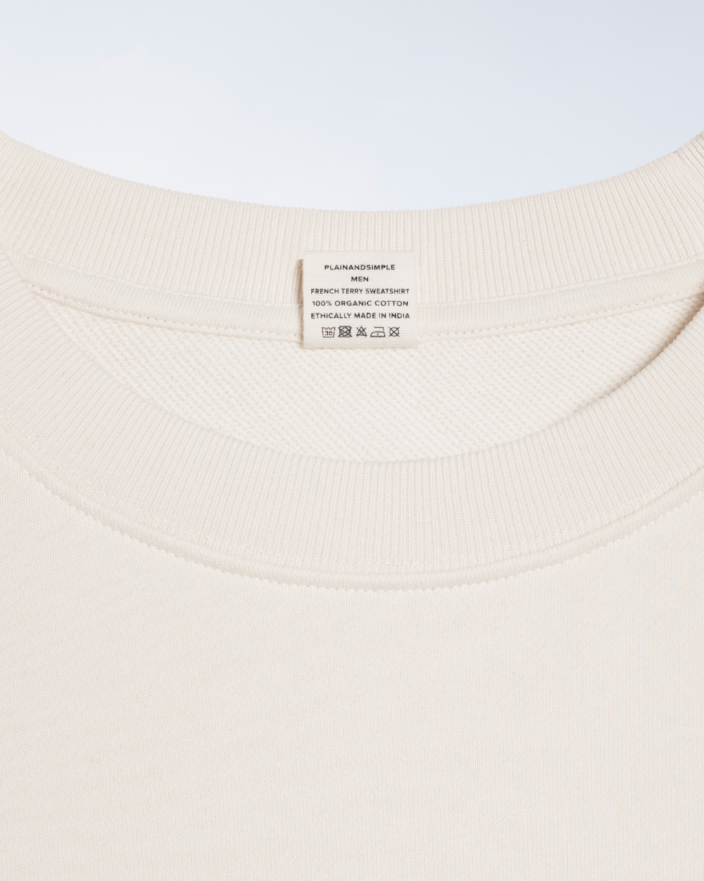 A close up of the neck label in a natural coloured, organic cotton sweatshirt.