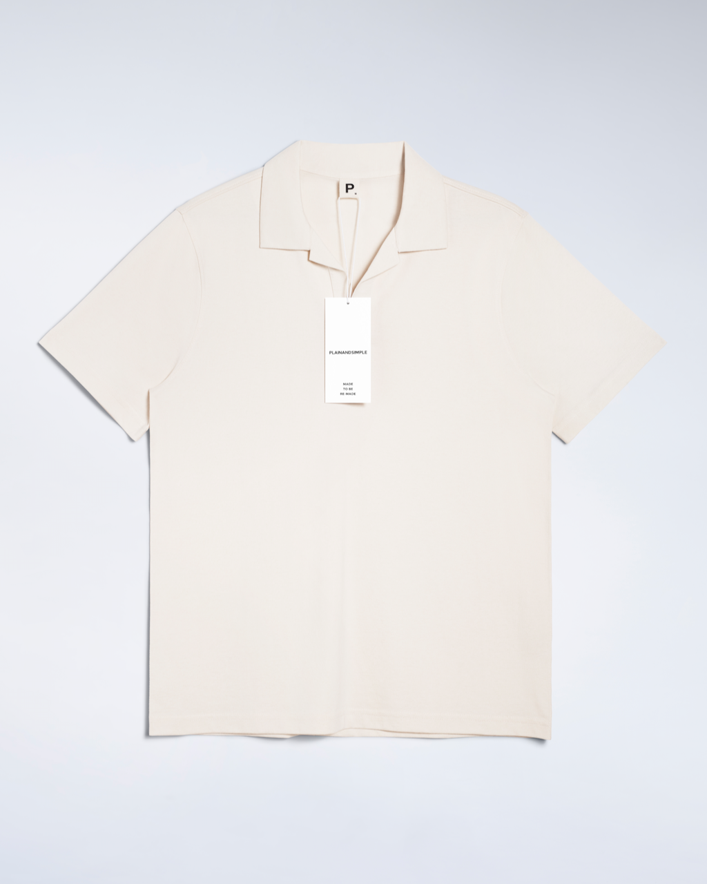 A flatly of a natural coloured, open neck, organic cotton polo shirt.