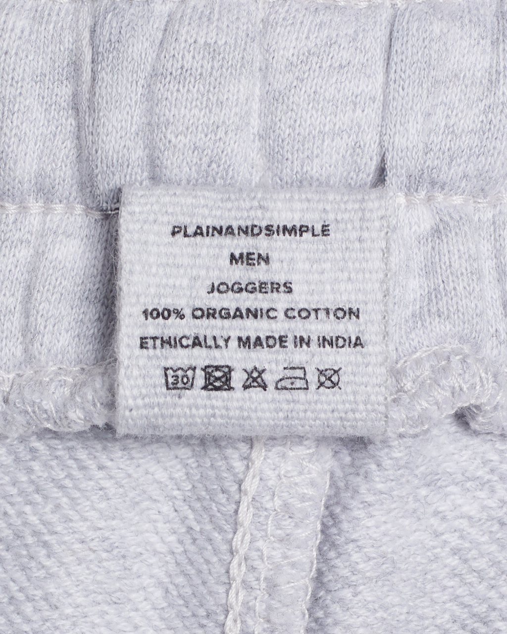 A close up of a label, for a pair of grey, organic cotton joggers.