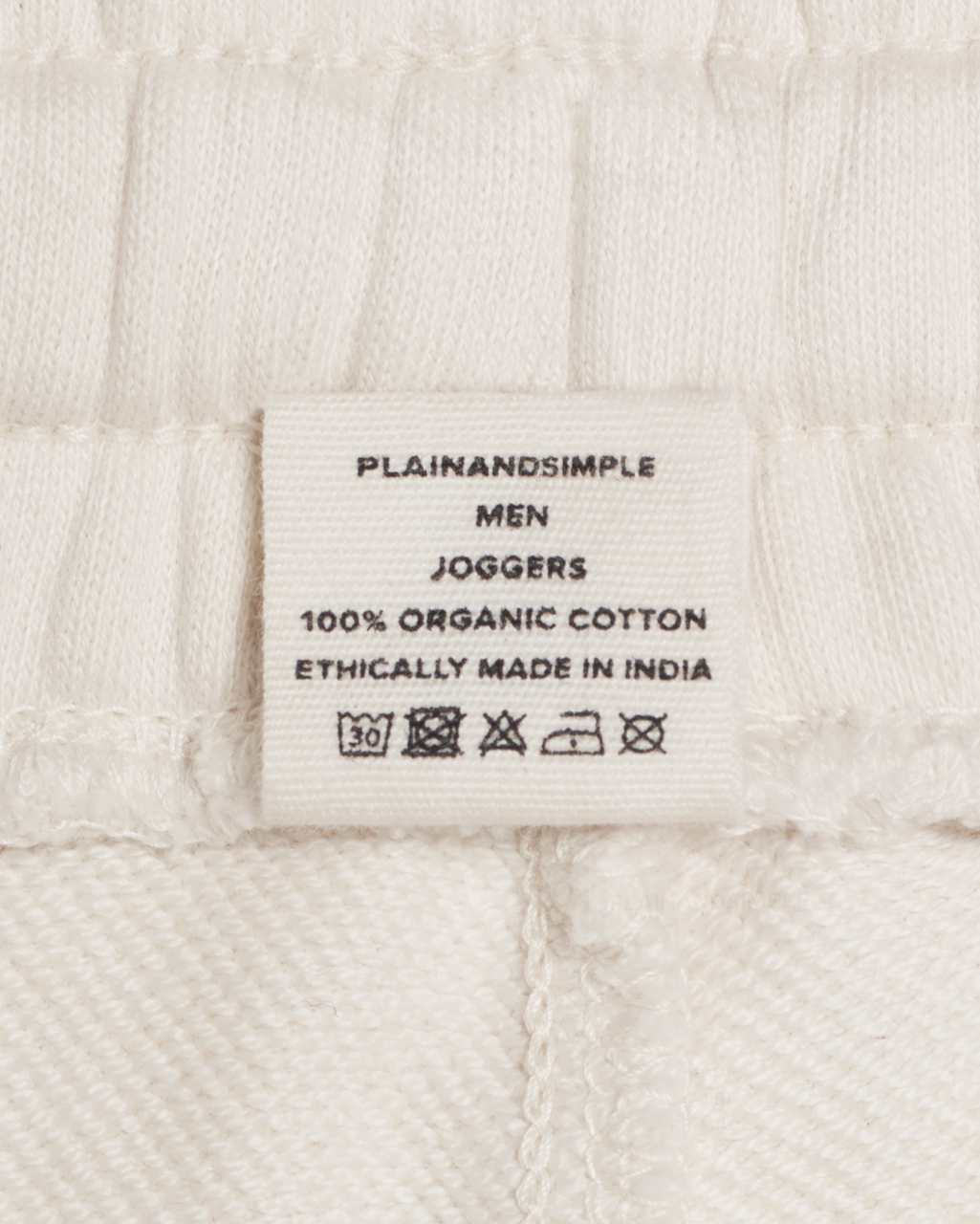 A close up of the label in a pair of natural coloured, organic cotton joggers.