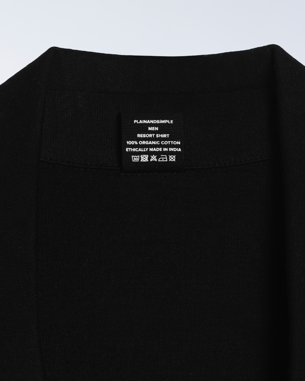 A close up of the neck label in a black, organic cotton resort shirt.