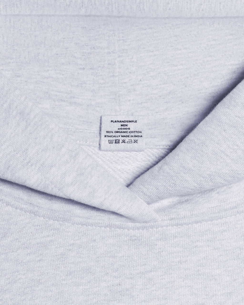 A close up of a neck label in a men's grey oversized heavyweight organic cotton hoodie.