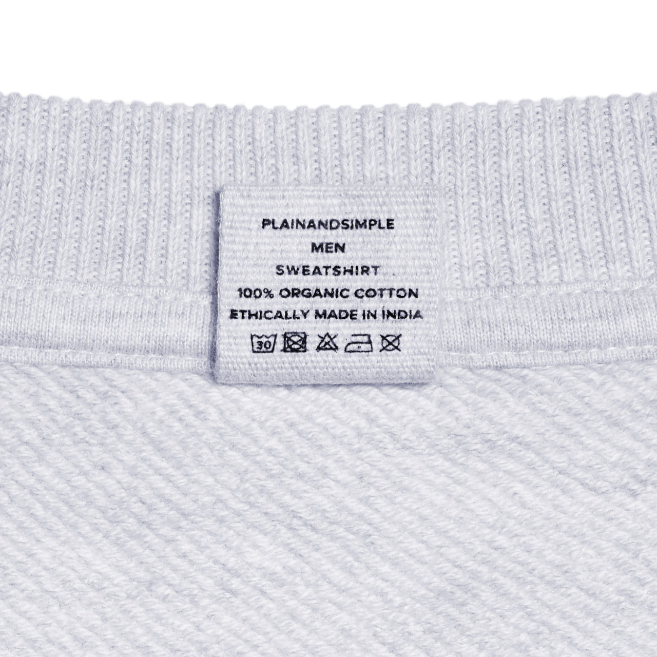 A close up of a neck label in a men's grey oversized heavyweight organic cotton sweatshirt.