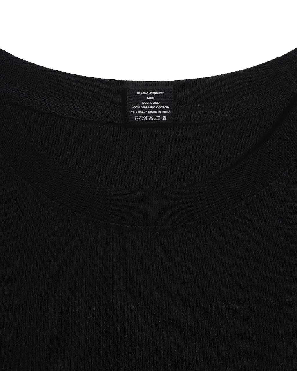 A close up of an neck label in a men's black oversized heavyweight organic cotton t shirt.