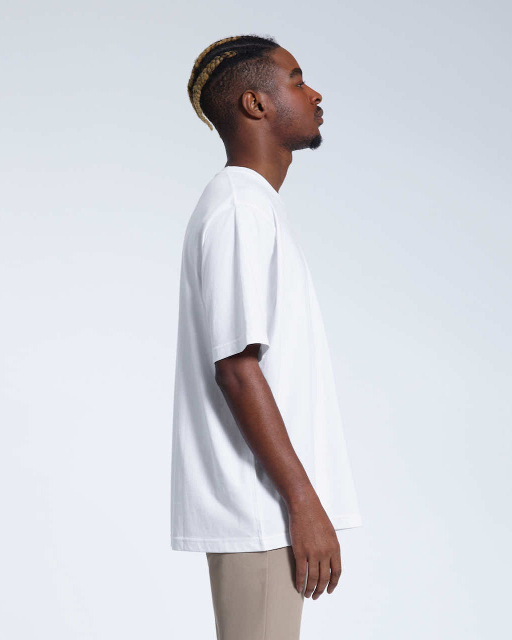 A man facing side on, modelling a plain white oversized heavyweight organic cotton t shirt.