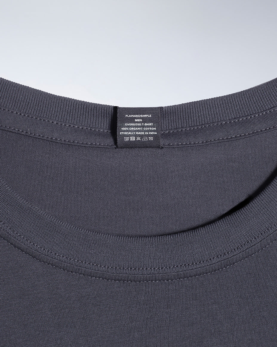 A close up of a neck label in a men's dark grey, oversized, organic cotton t shirt.