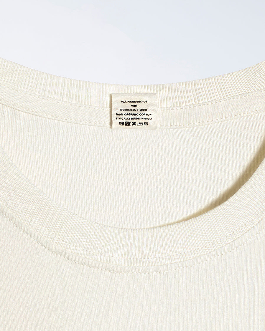 A close up of a neck label in a men's ecru, oversized, organic cotton t shirt.
