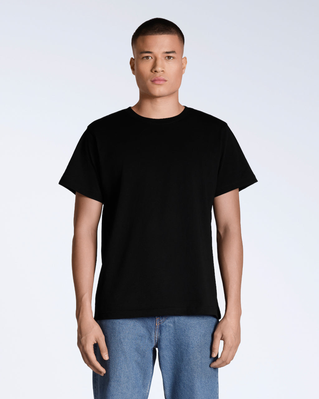 A man facing front on looking into the camera, modelling a plain black, organic cotton t shirt.