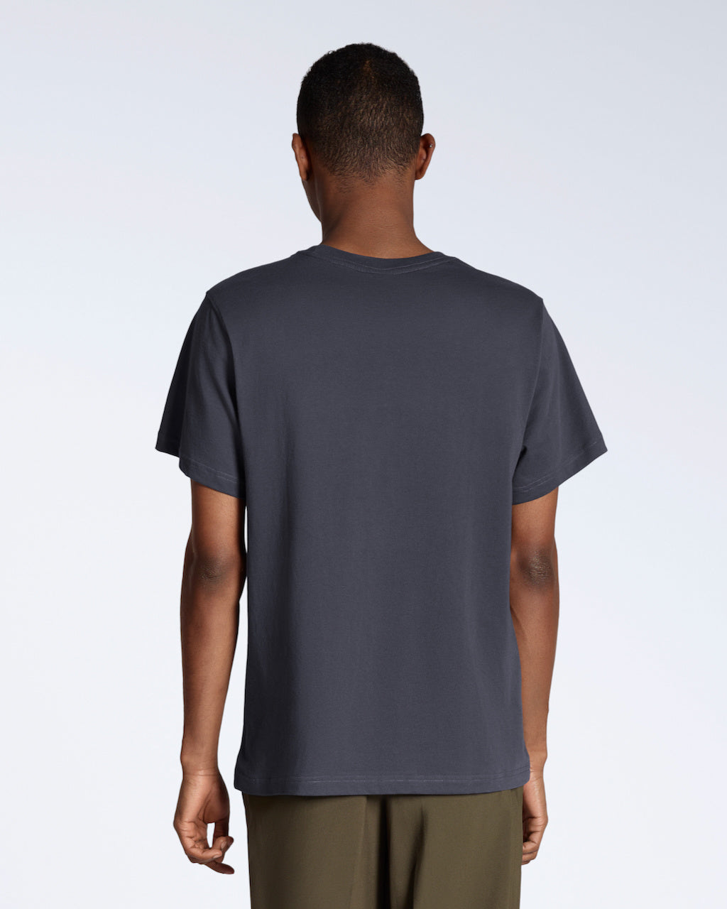 A man facing away from the camera, modelling a plain dark grey, short sleeve organic cotton t shirt.